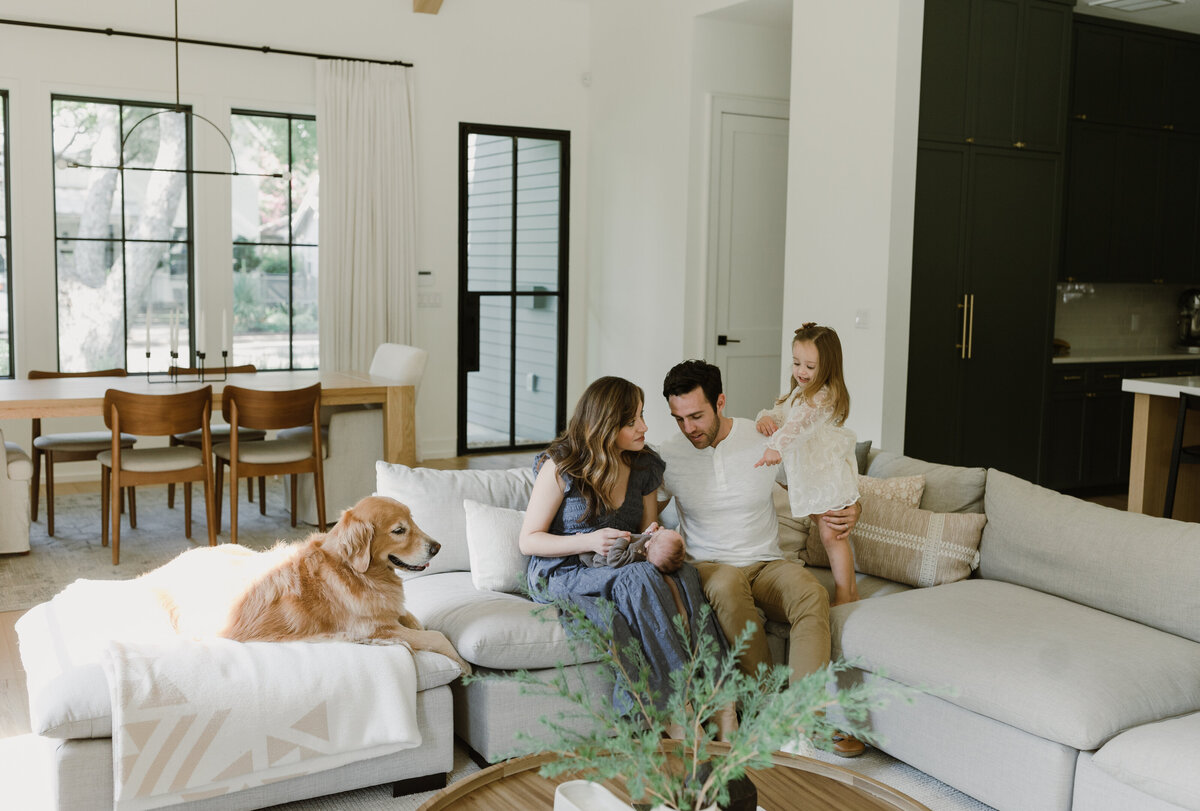 Family in living room with dog and young child