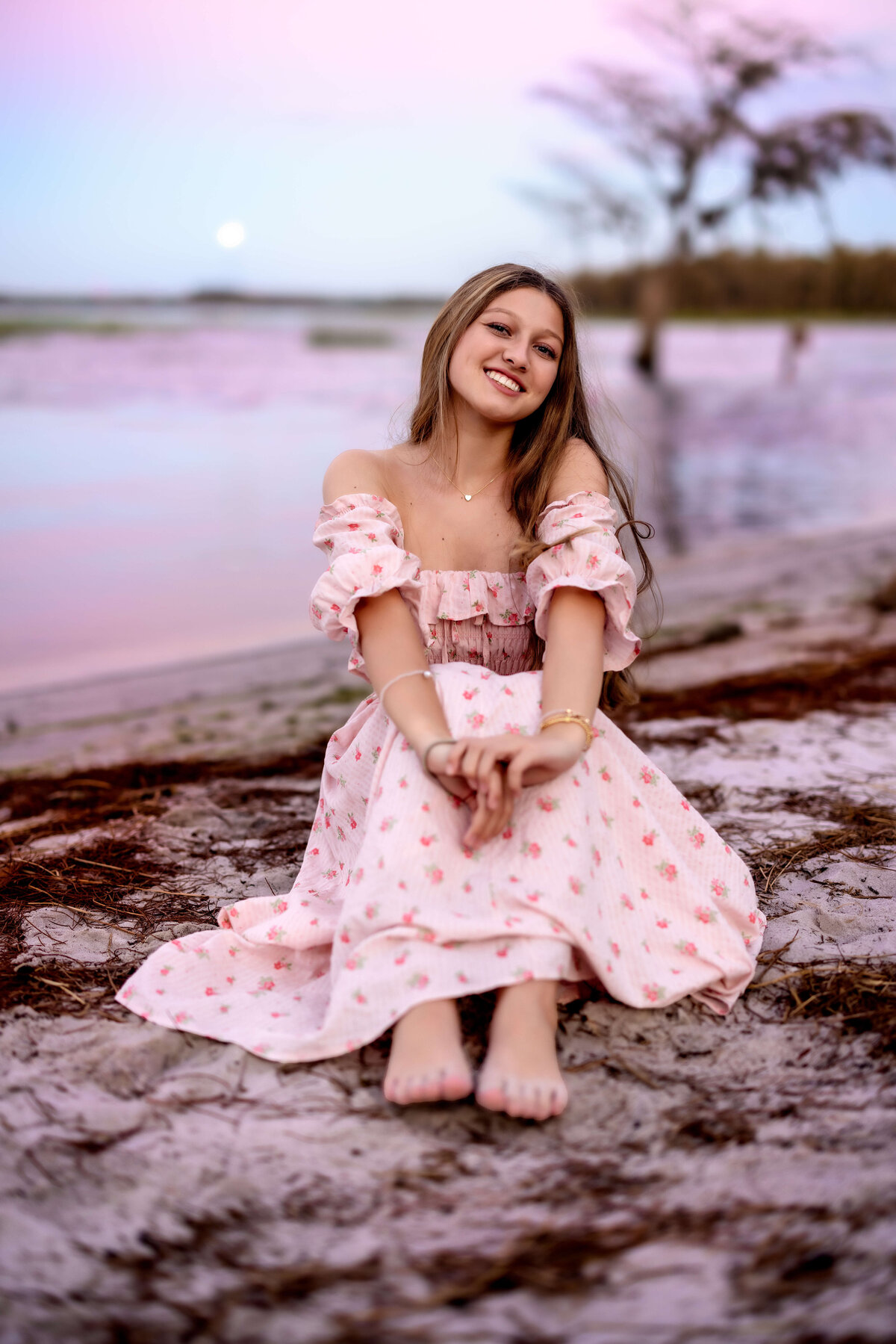 Senior girl posing near the water during blue hour photo session in Winter Garden, Florida