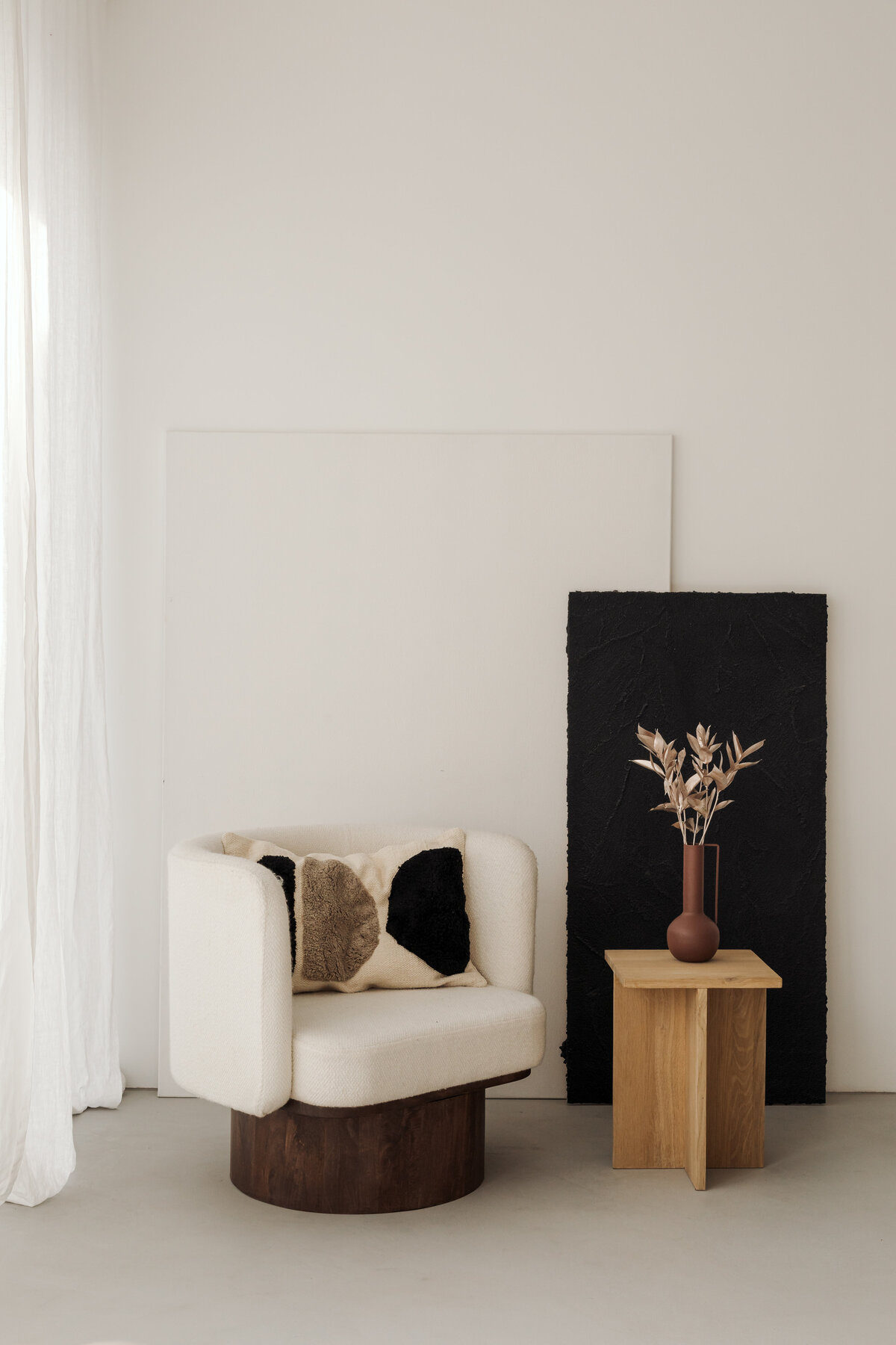 kaboompics_a-cozy-cream-colored-armchair-placed-next-to-minimalist-black-and-white-artwork-with-a-small-side-table-adorned-with-natural-objects-36990