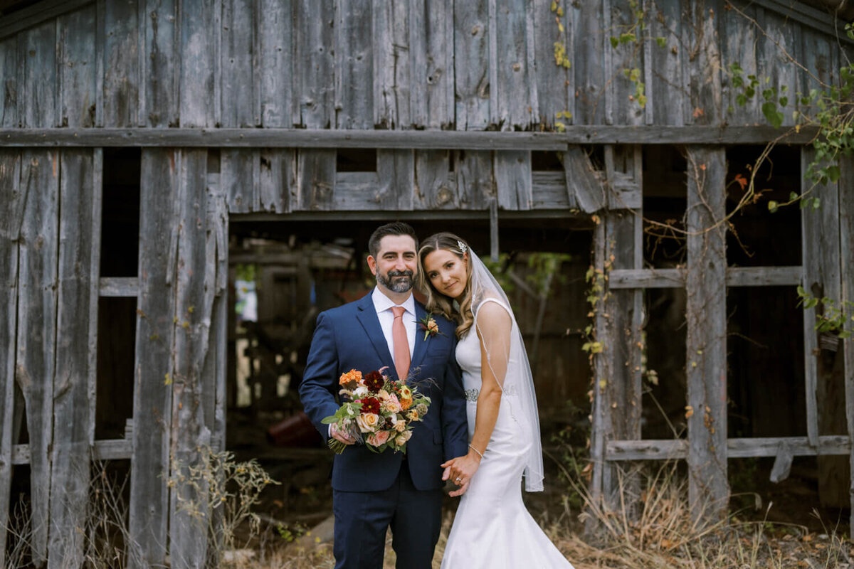 couples-portrait-in-front-of-old-weathered-barn
