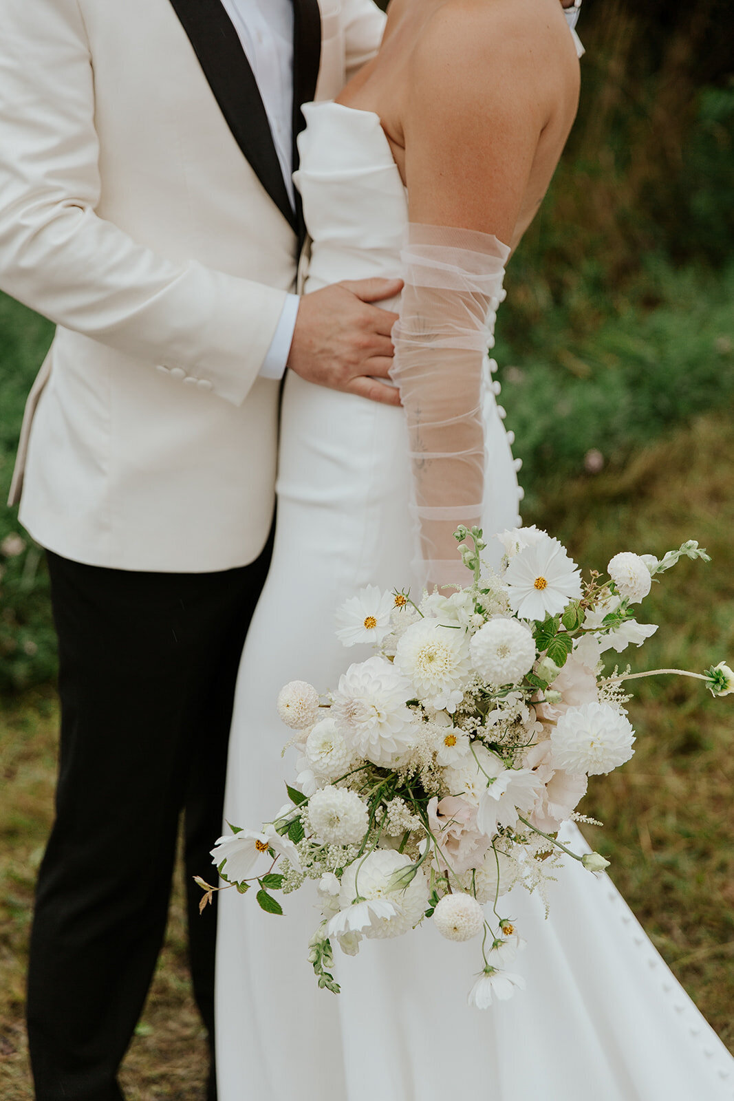 A bride holds a textured, garden bouquet of white flowers at a Montreal wedding.