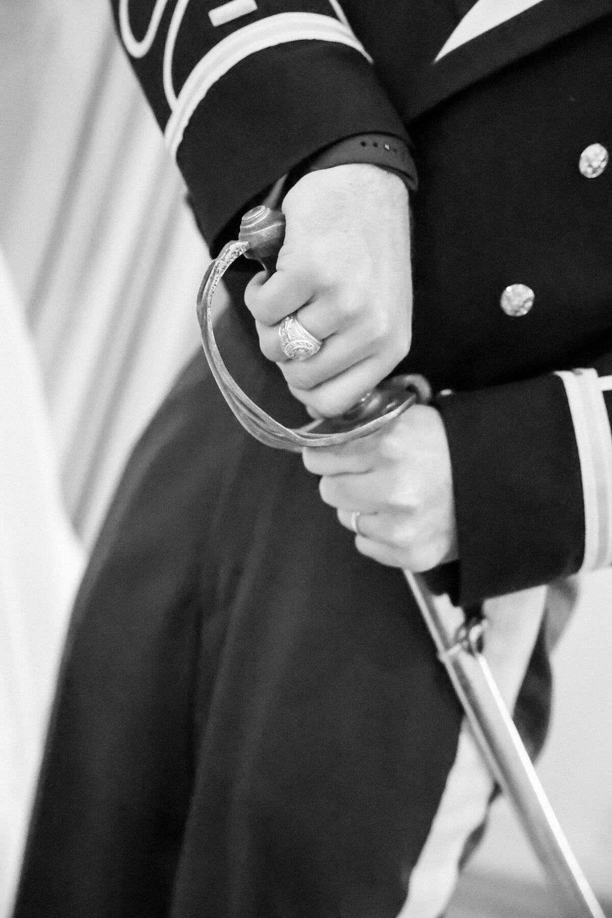 black and white aggie wedding groom holds saber in military uniform at wedding near austin texas