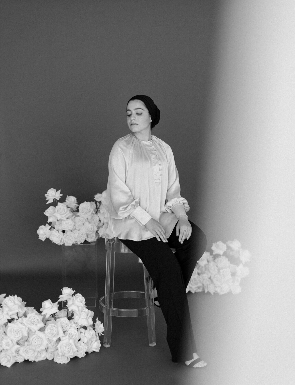 soft, ethereal photo of woman with white roses and dark background, florist brand photography