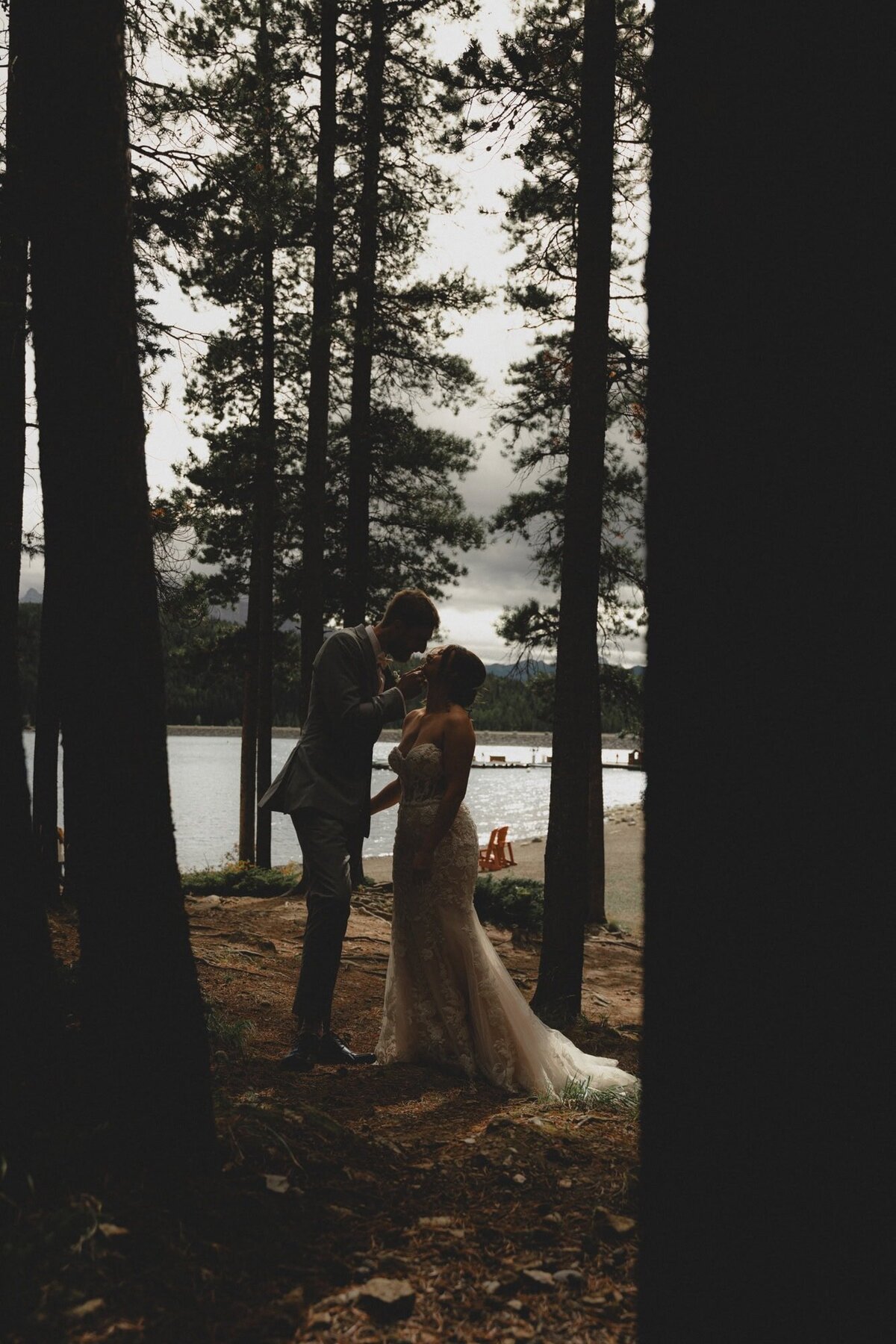 Wedding couple look at each other at Lake Minnewanka in Banff