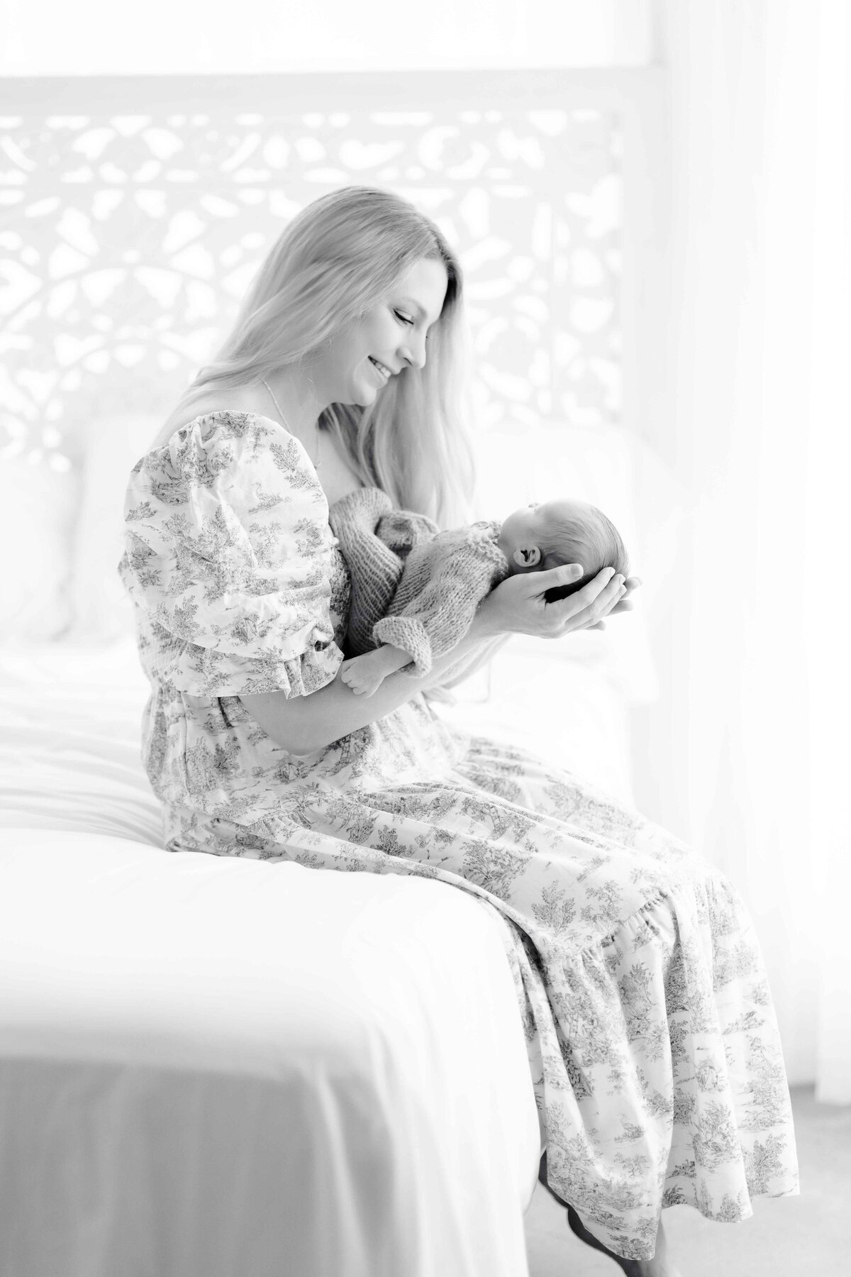 mom holds baby close to her face for newborn portrait sesssion