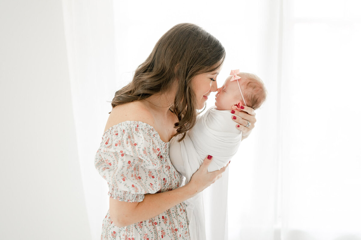 A mother kisses her newborn in Nashville newborn photographer Kristie Lloyd's studio