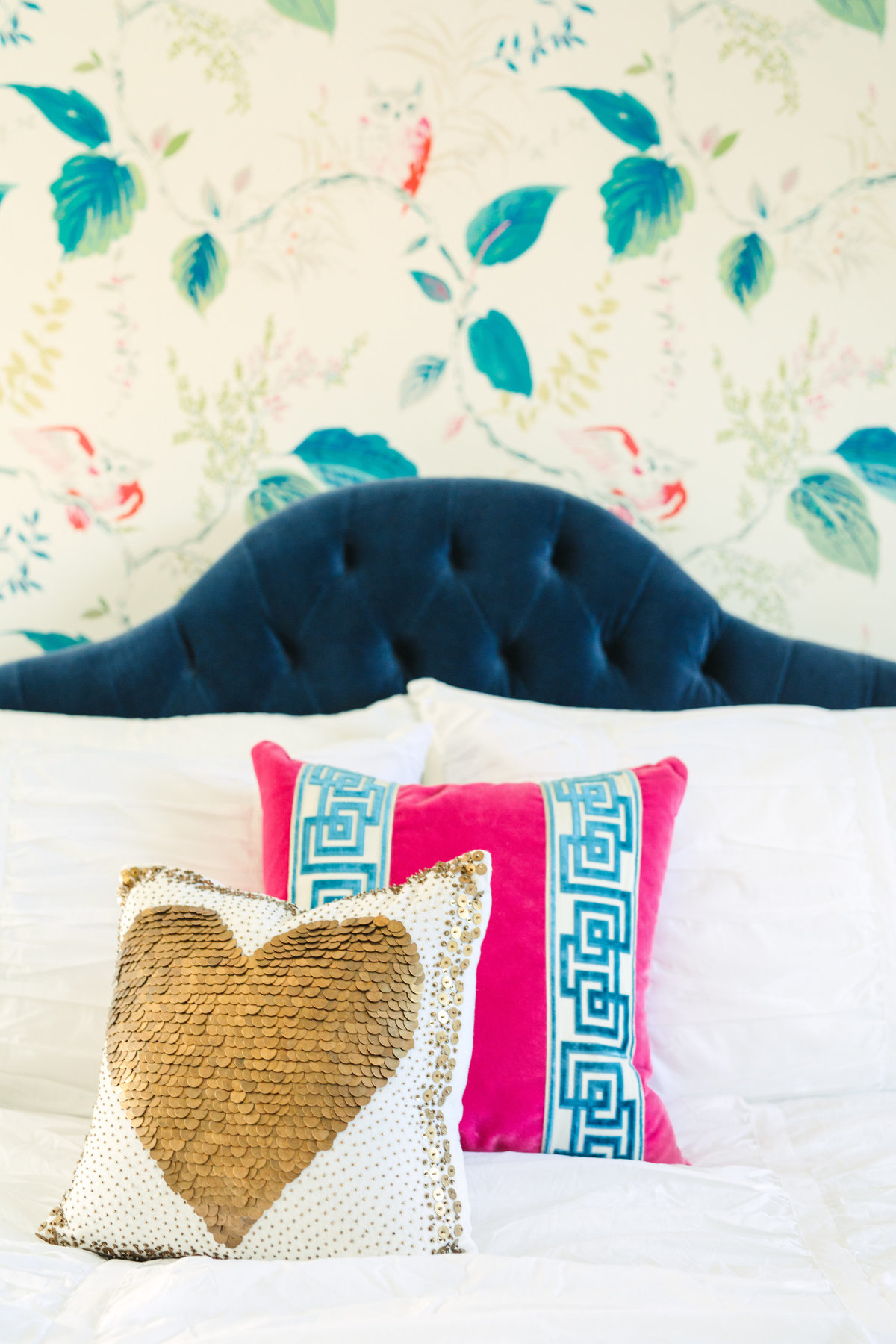 Bedroom with Kate Spade Owlish wallpaper, navy velvet bed, and hot pink throw pillow