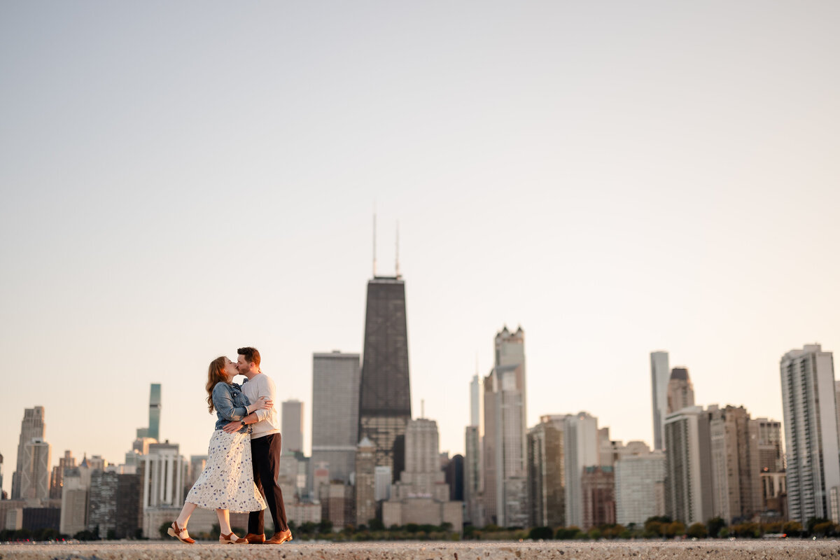 A couple kiss in front of the Chicago Skyline at North Avenue Beach