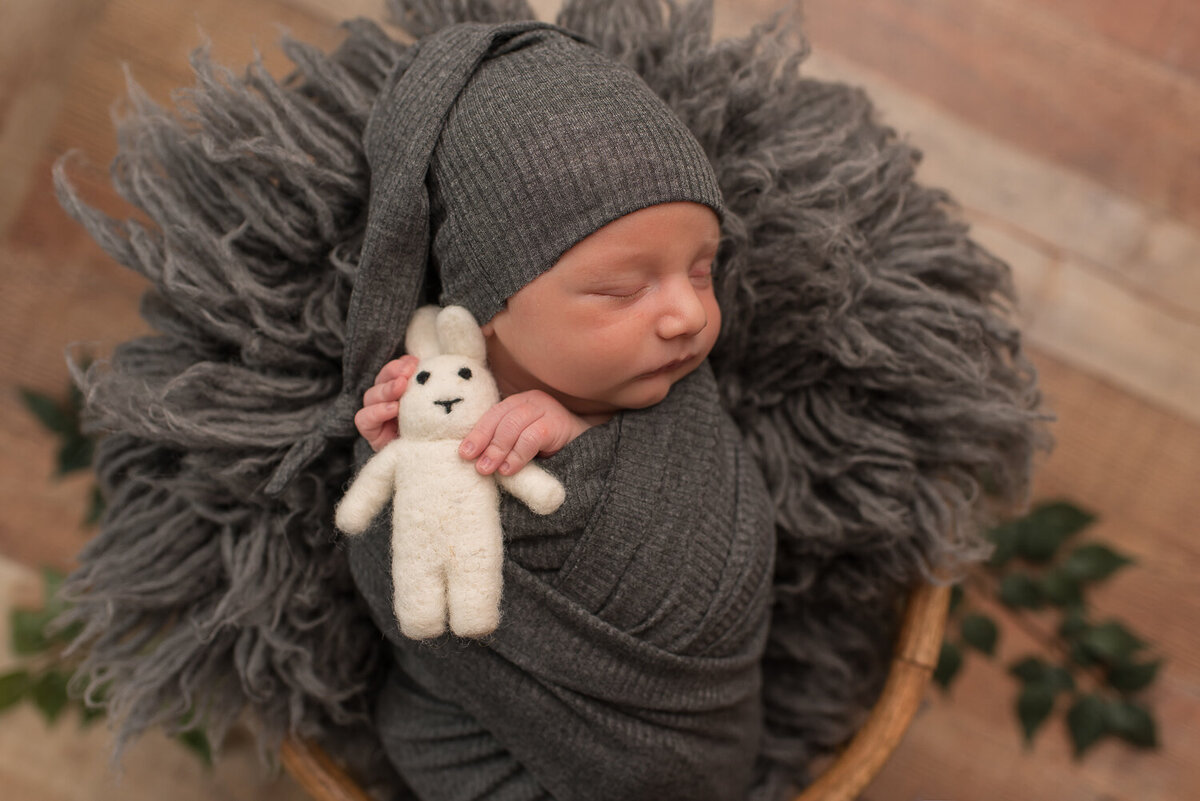 Baby wrapped in gray, holding white bunny at neutral newborn session |Sharon Leger Photography | Canton, CT Newborn & Family Photographer