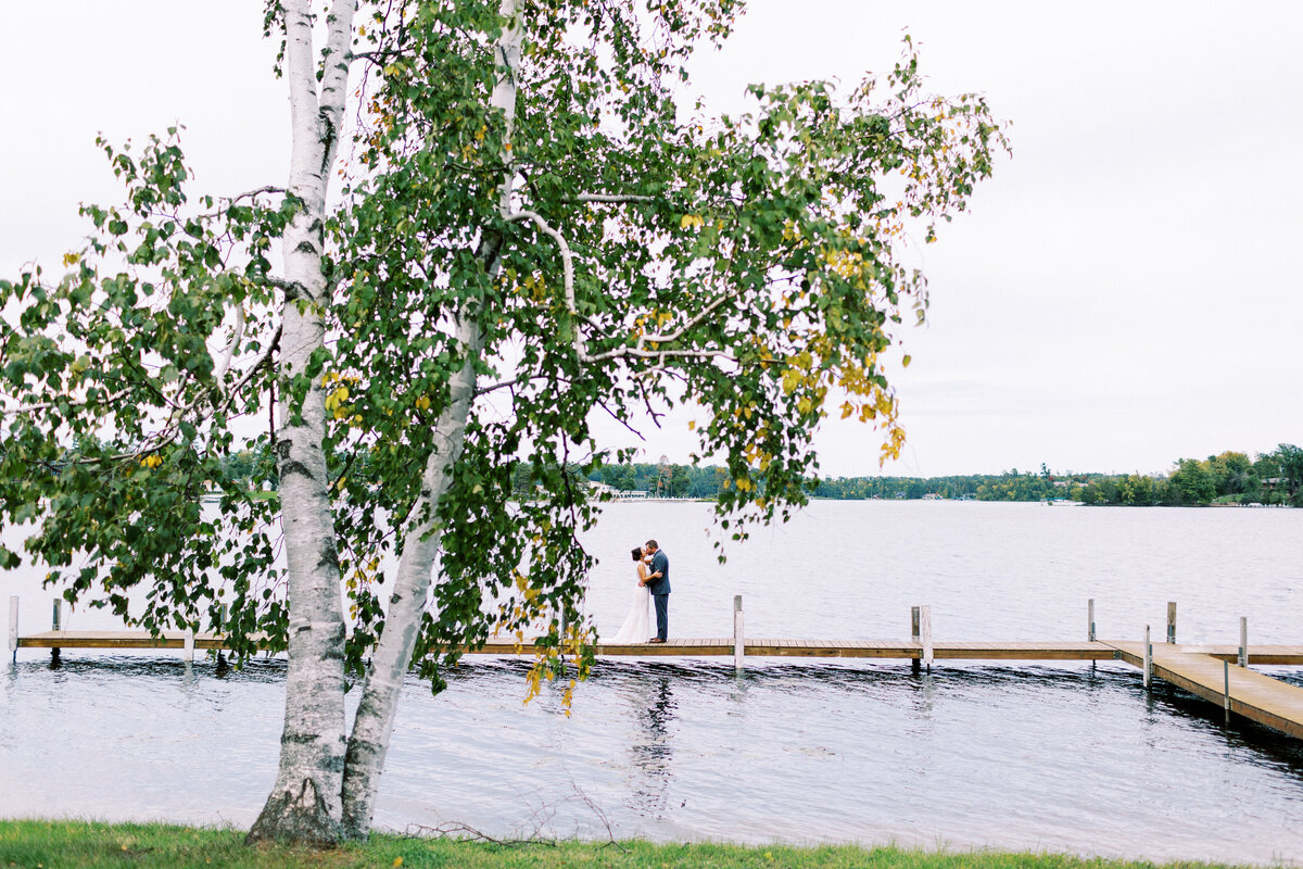 Groom kissing his bride and the Gull Lake MN