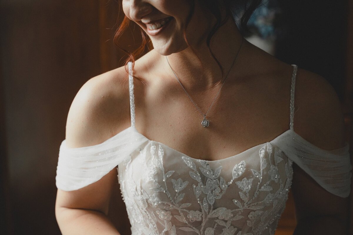 Bride smiling in front of window in The Norland Historic Estate in Lethbridge