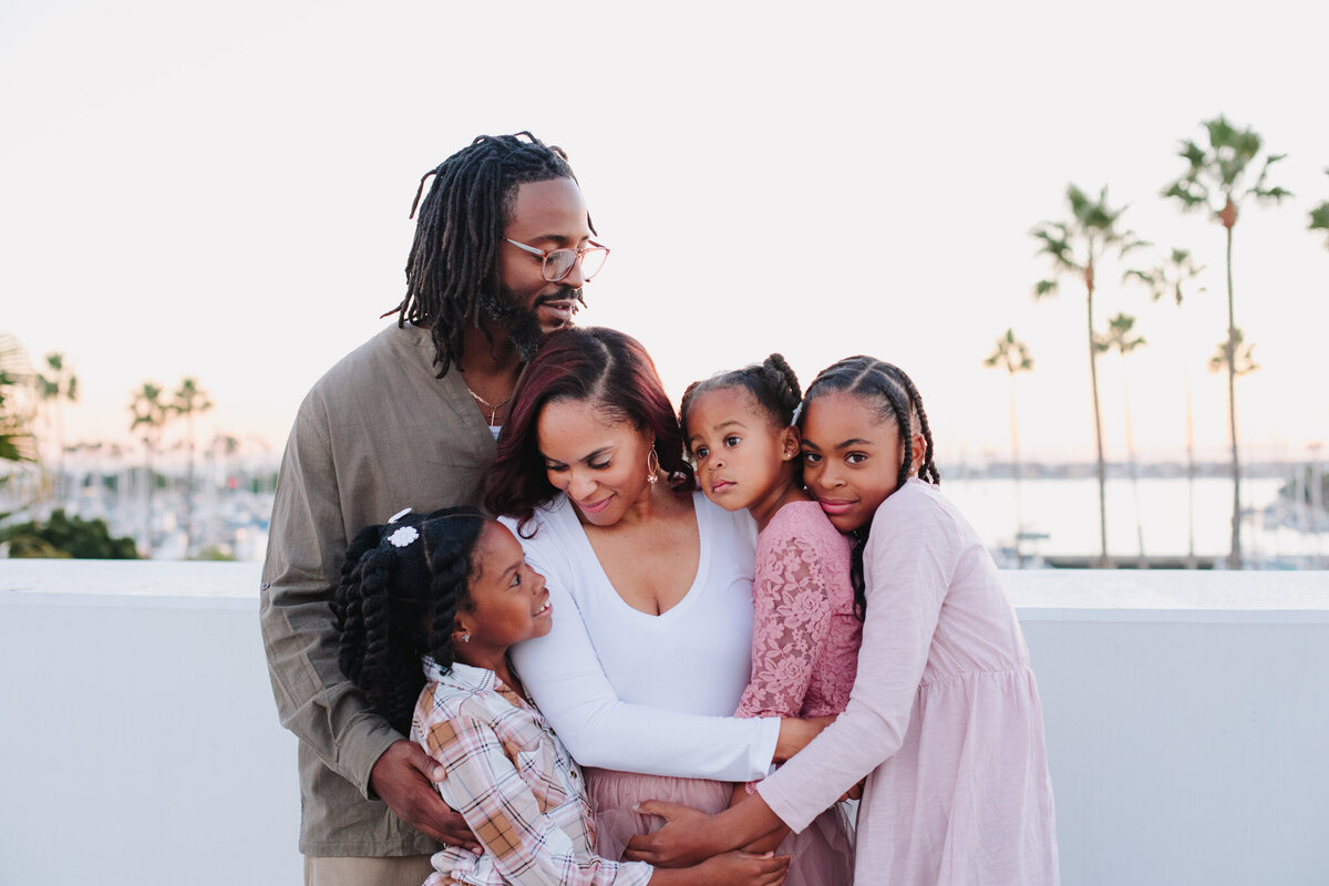 Family of five dad bringing wife and children in big hug during outdoor family session