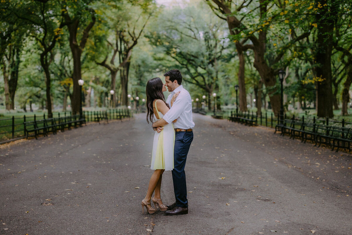 The engaged couple wraps their arms around each other amidst the lovely foilage at Central Park, NYC. Image by Jenny Fu Studio.