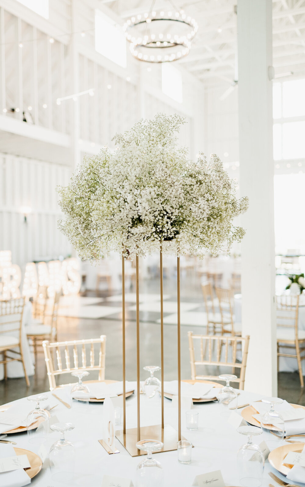 Elegant table centerpiece featuring a tall gold stand adorned with delicate baby's breath flowers at Ashford Acres Inn, Cynthiana, KY.