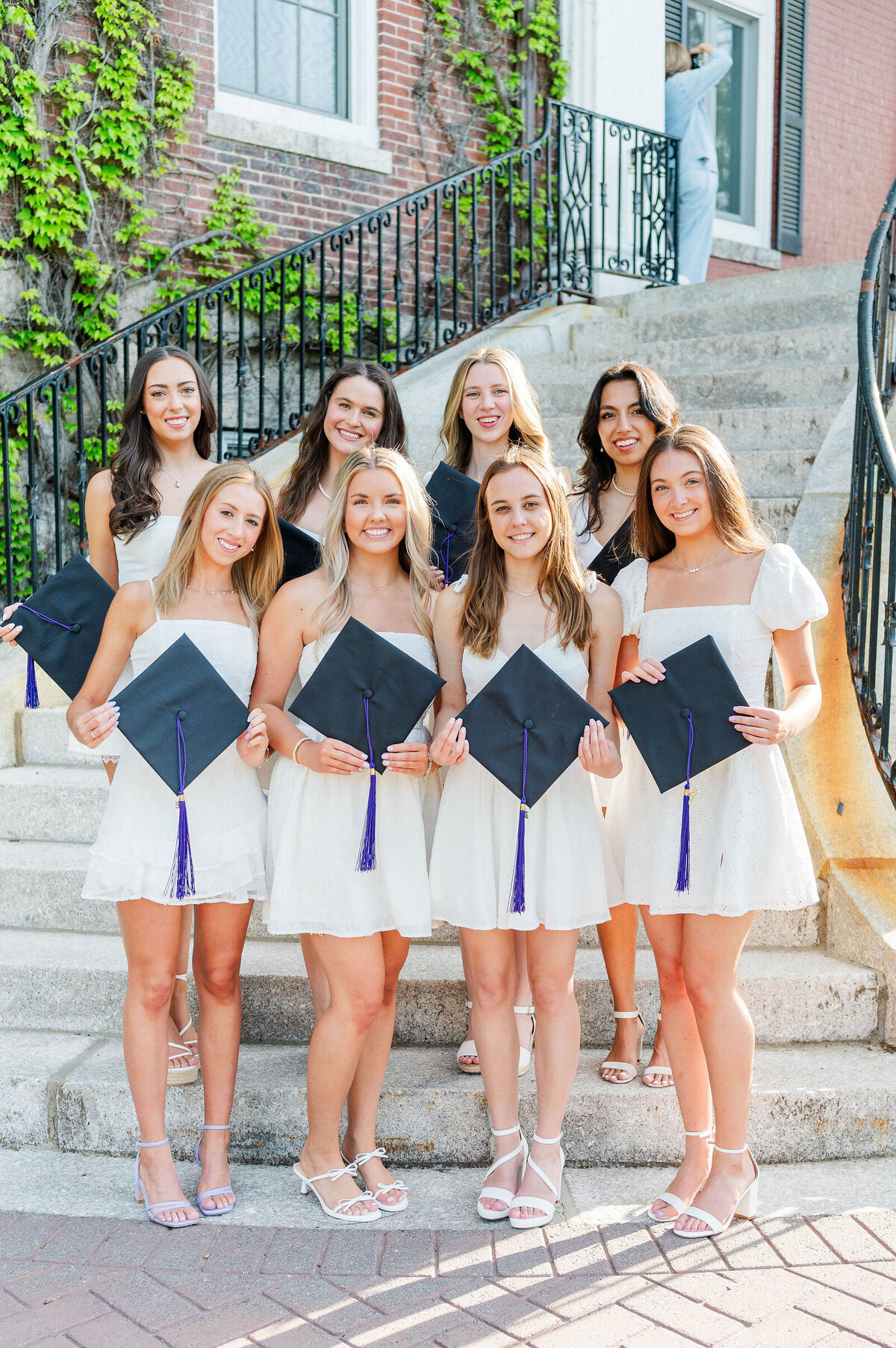 Group of college grads holding caps at Assumption University taken by best college grad photographer in Worcester, MA