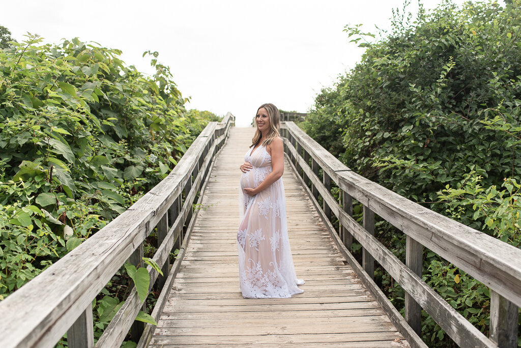 Expecting mom in white dress on boardwalk at the beach |Sharon Leger Photography || Canton, CT || Family & Newborn Photographer