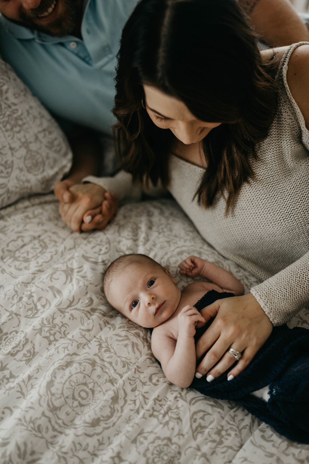 Mom holds baby on bed