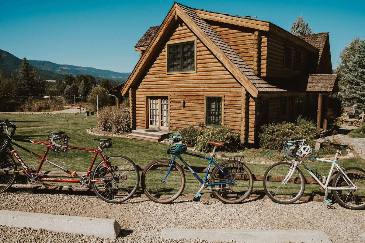 A wooden cabin with bikes lined up in front of it. 