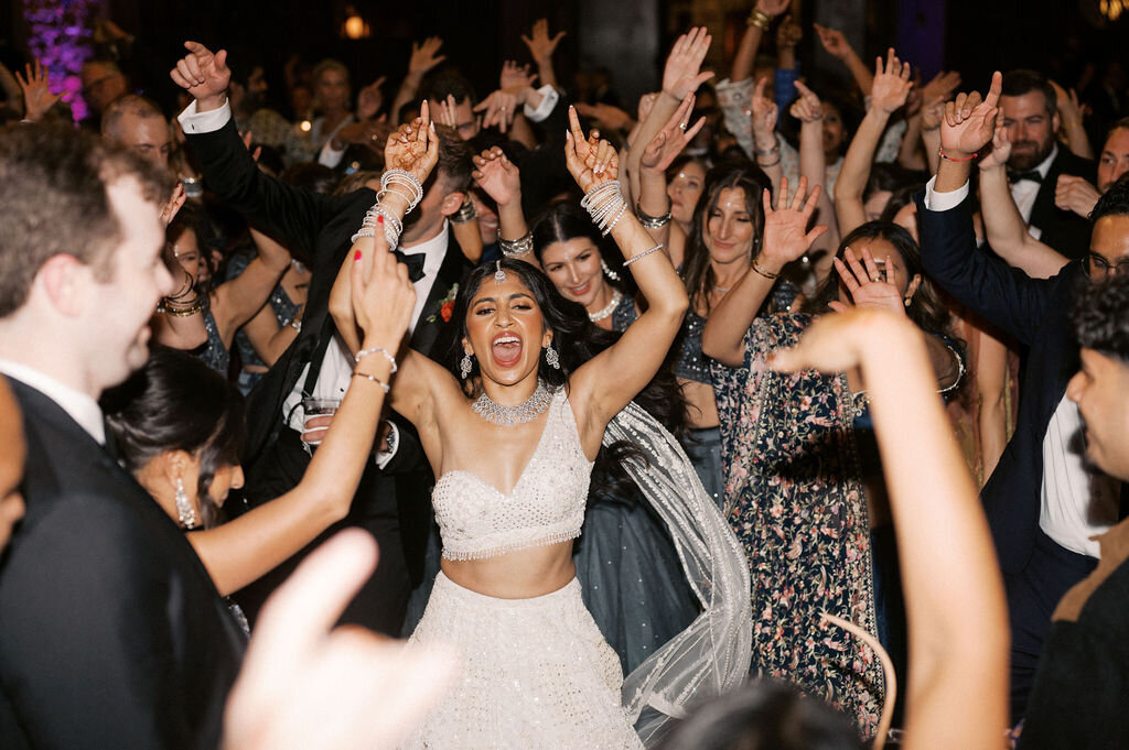 Bride celebrating with friends on the dance floor, surrounded by cheering guests during the reception in Highlands, North Carolina.