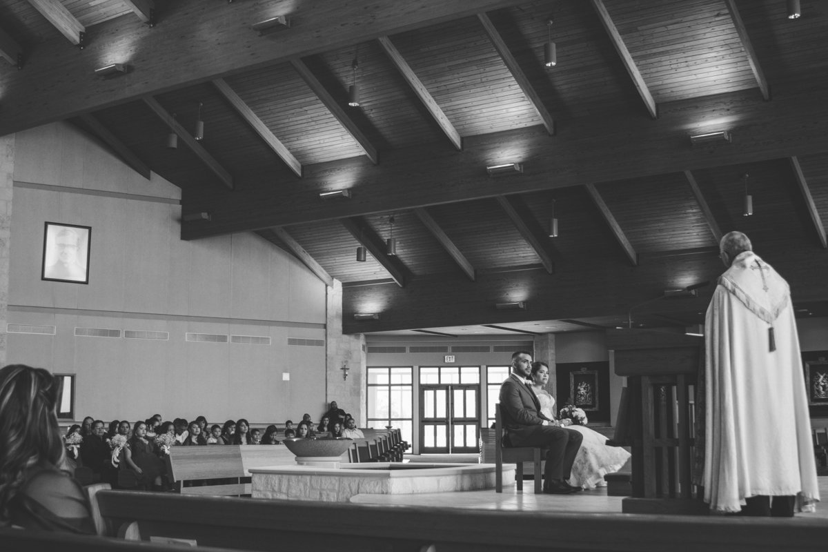couple sitting at alter during wedding ceremony at St. Anthony Claret Catholic Church San Antonio