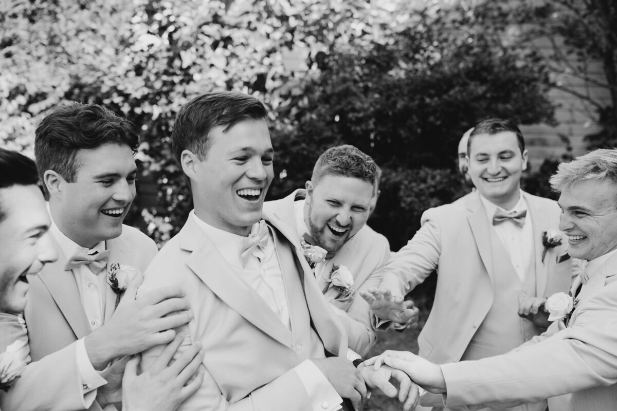 Bride and groom smiling with their wedding party outdoors during a sunny South Bend wedding.