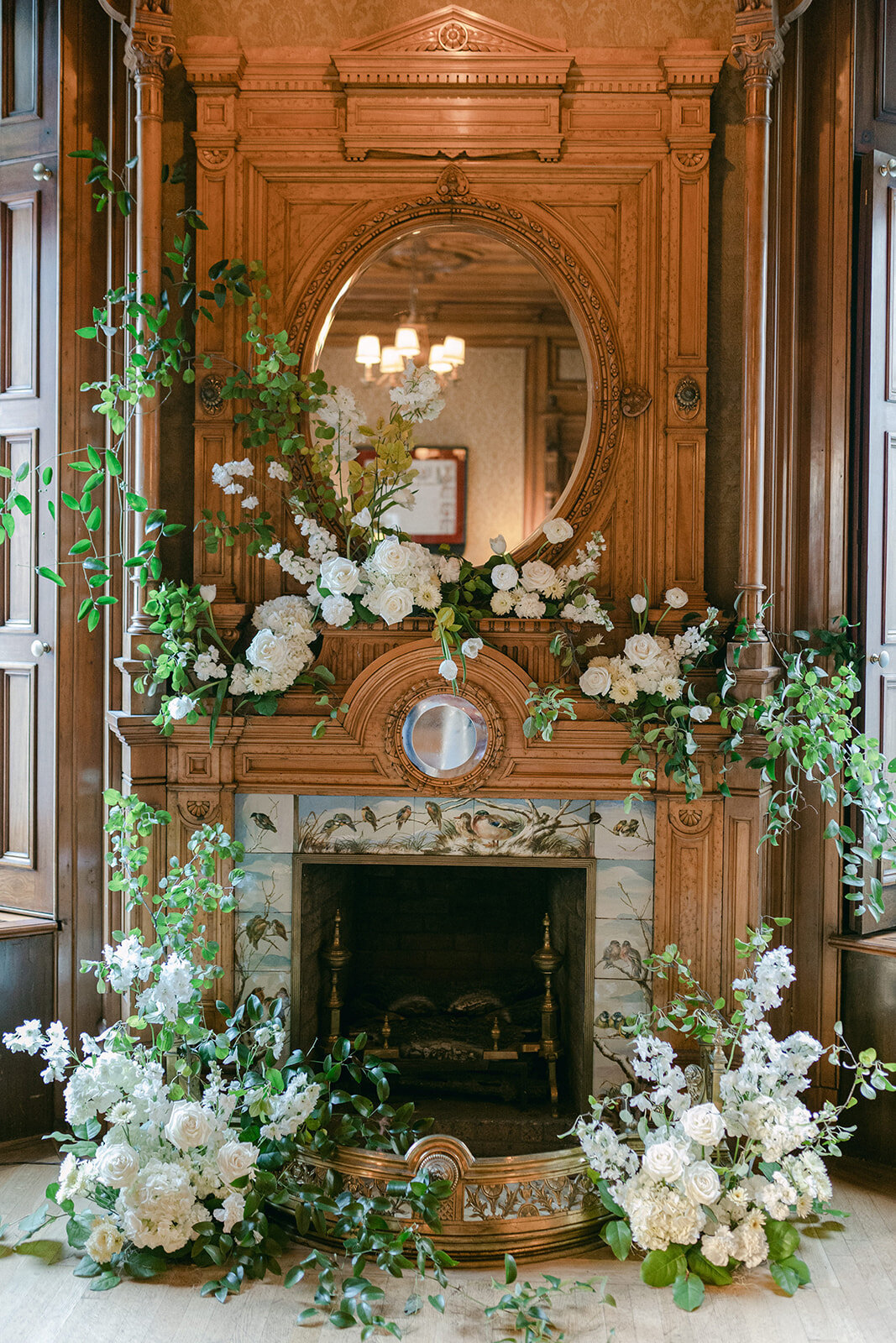Lush, white flowers adorn a wooden fireplace for a wedding ceremony at Mount Stephen.  