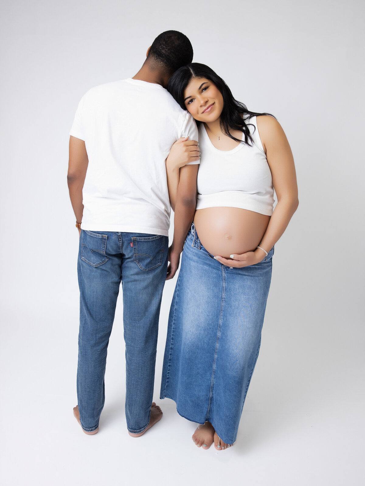 A pregnant woman posing with her husband