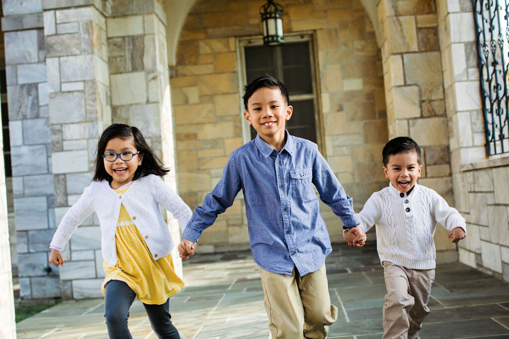 Three kids run and hold hands.