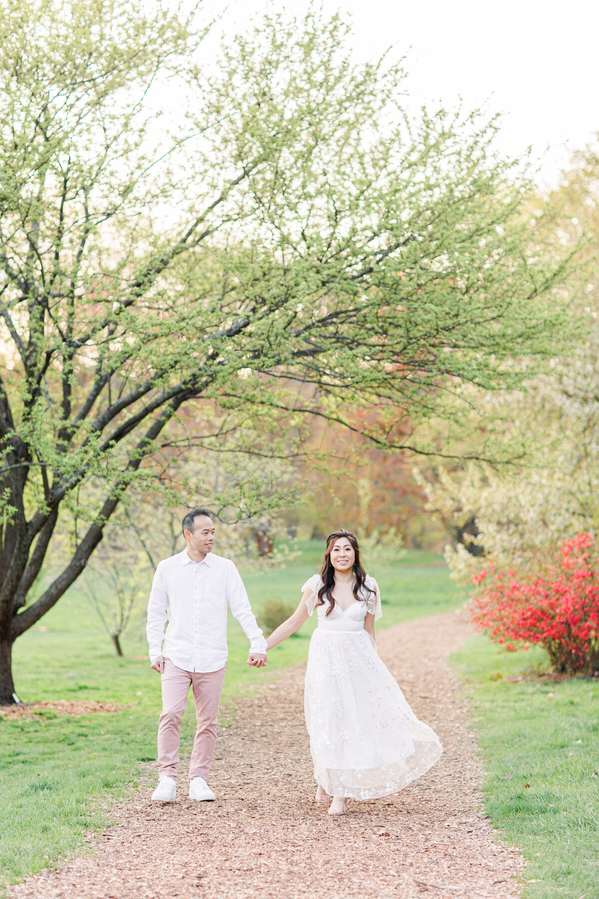 Couple holding hands and walking towards the camera representing romantic Boston engagement pictures