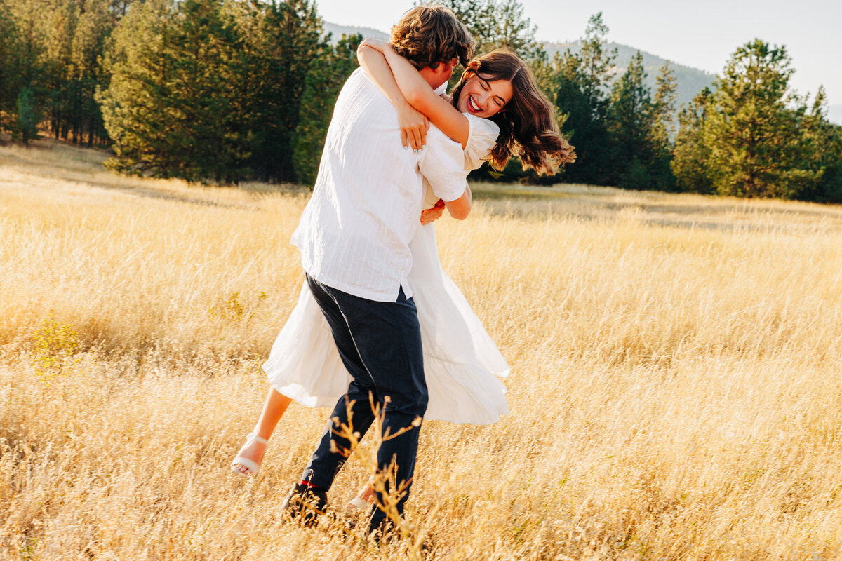 Engaged couple swinging around at Blue Mountain in Missoula
