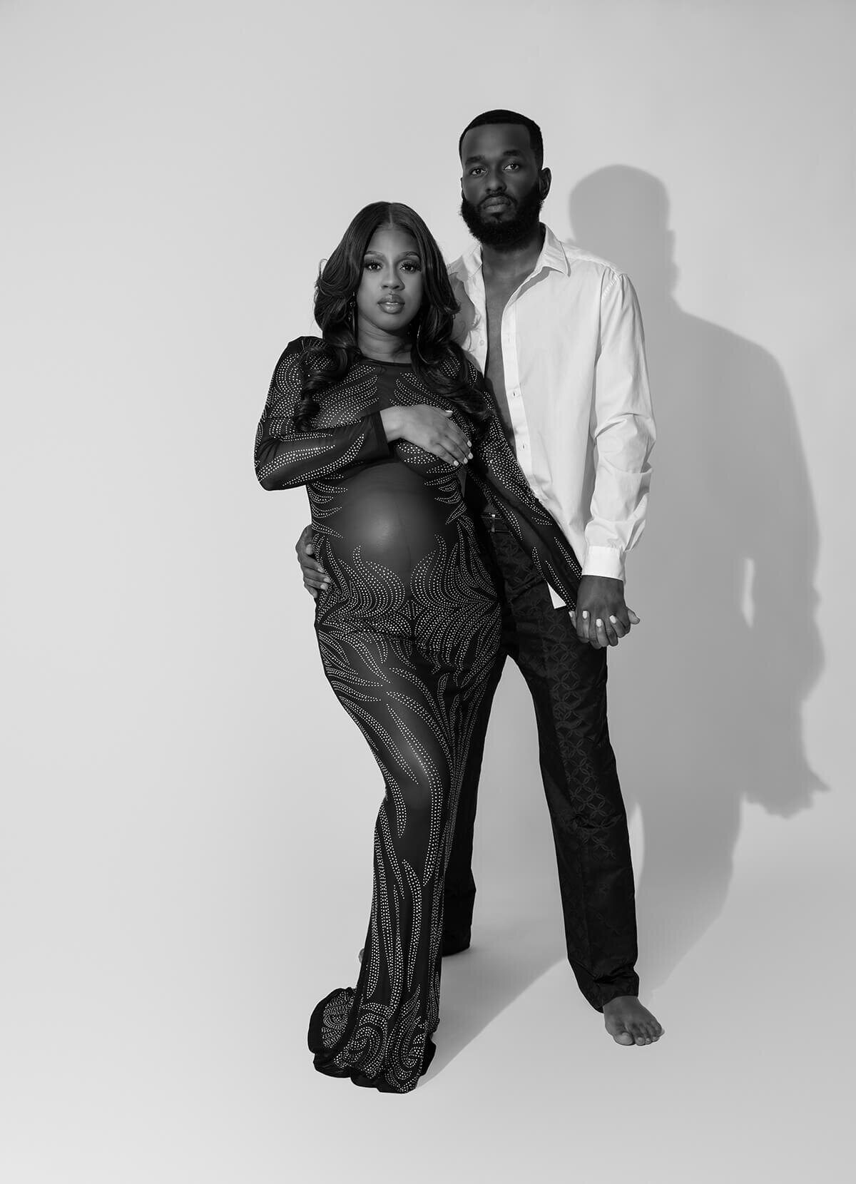 mom and dad posed with pregnant belly
