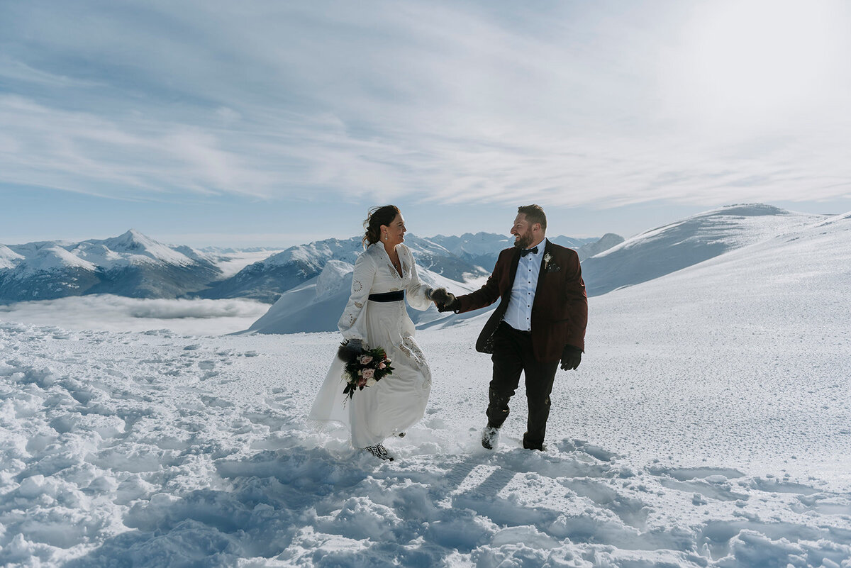Bride and groom walk across glacier after Blackcomb Helicopters Whistler wedding ceremony