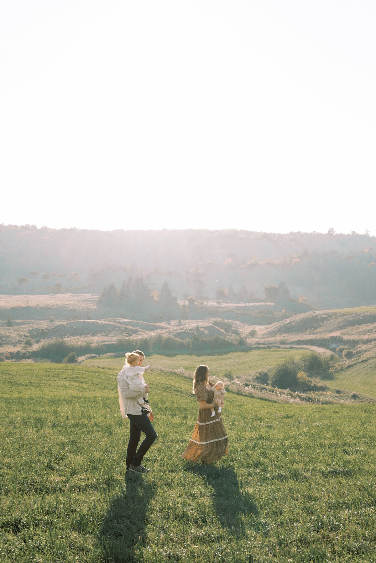 Couple walking in an open field with family in Ottawa