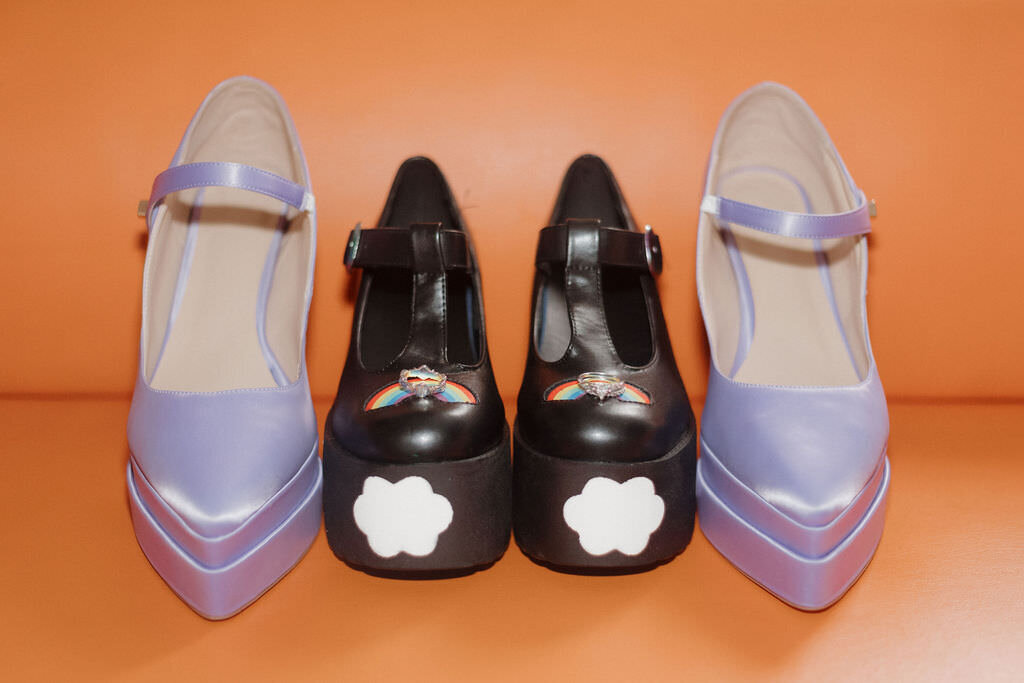 A pair of black heels with purple heels on either side.