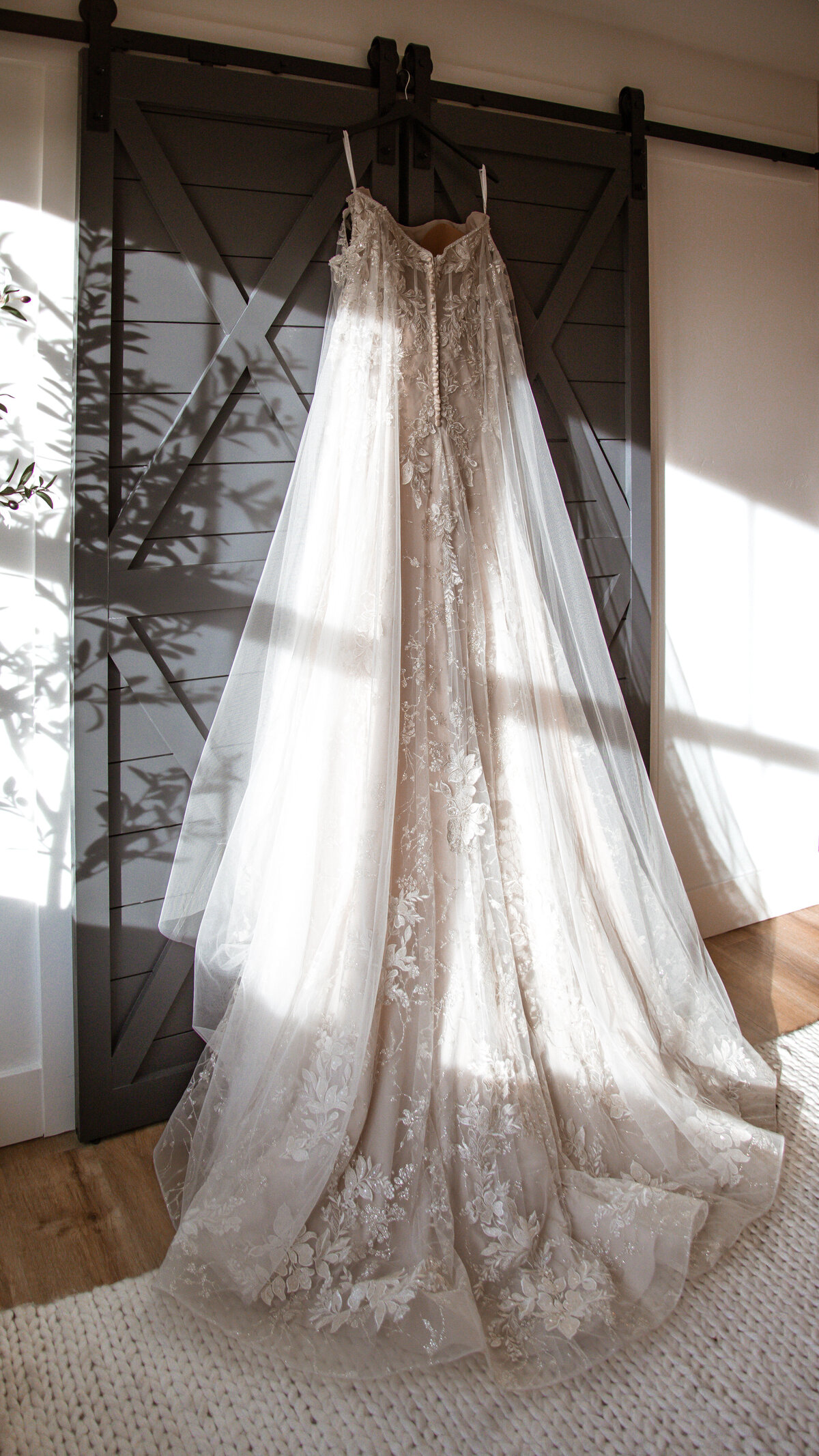 Wedding Dress on Black Indoor Barn Door with Sunbeams