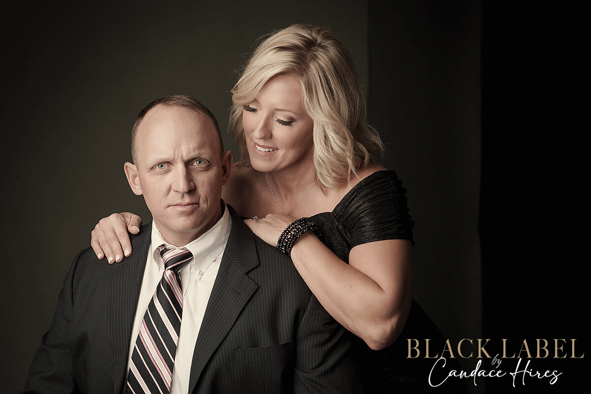 husband and wife photographed against a black backdrop