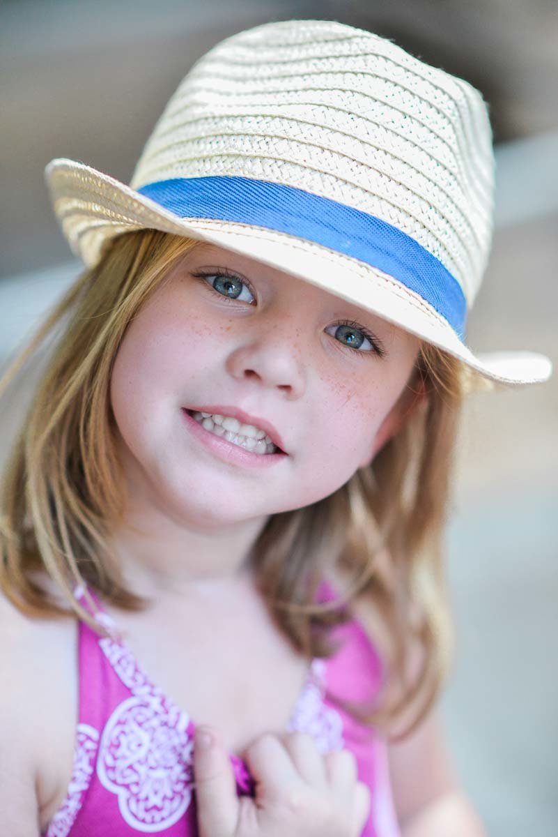 little girl in straw hat with blue eyes