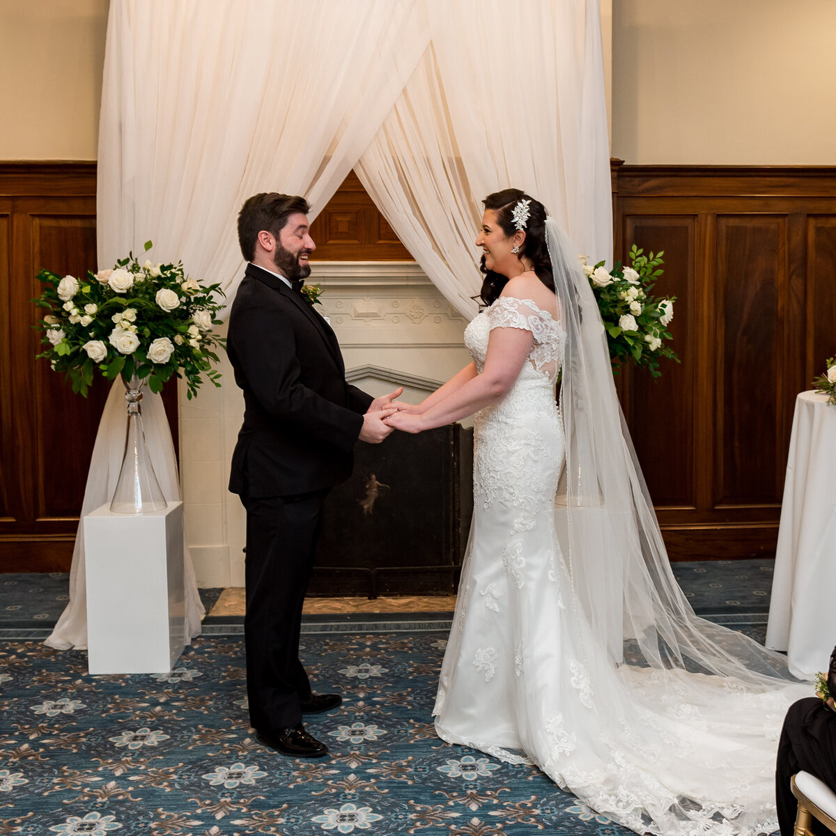a full length photo of a bride and groom at the altar holding hands during their Ottawa wedding ceremony at the Chateau Laurier