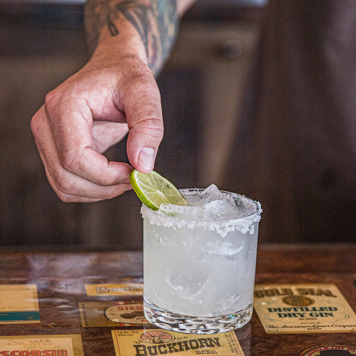 margarita photograph with hand on lime garnish