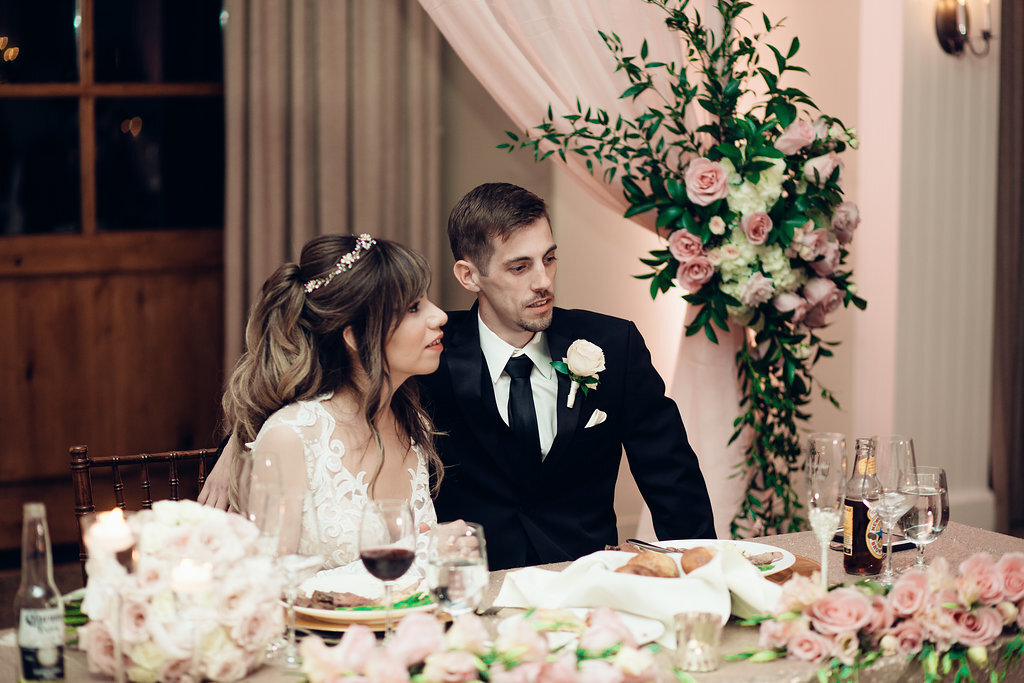 Wedding Photograph Of Bride And Groom Seated in a Decorated Table Los Angeles