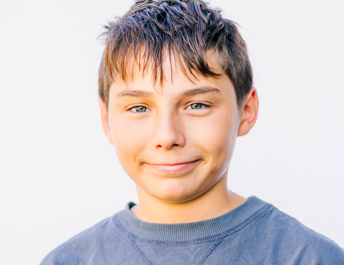 Portrait of middle school boy with relaxed expression, white background