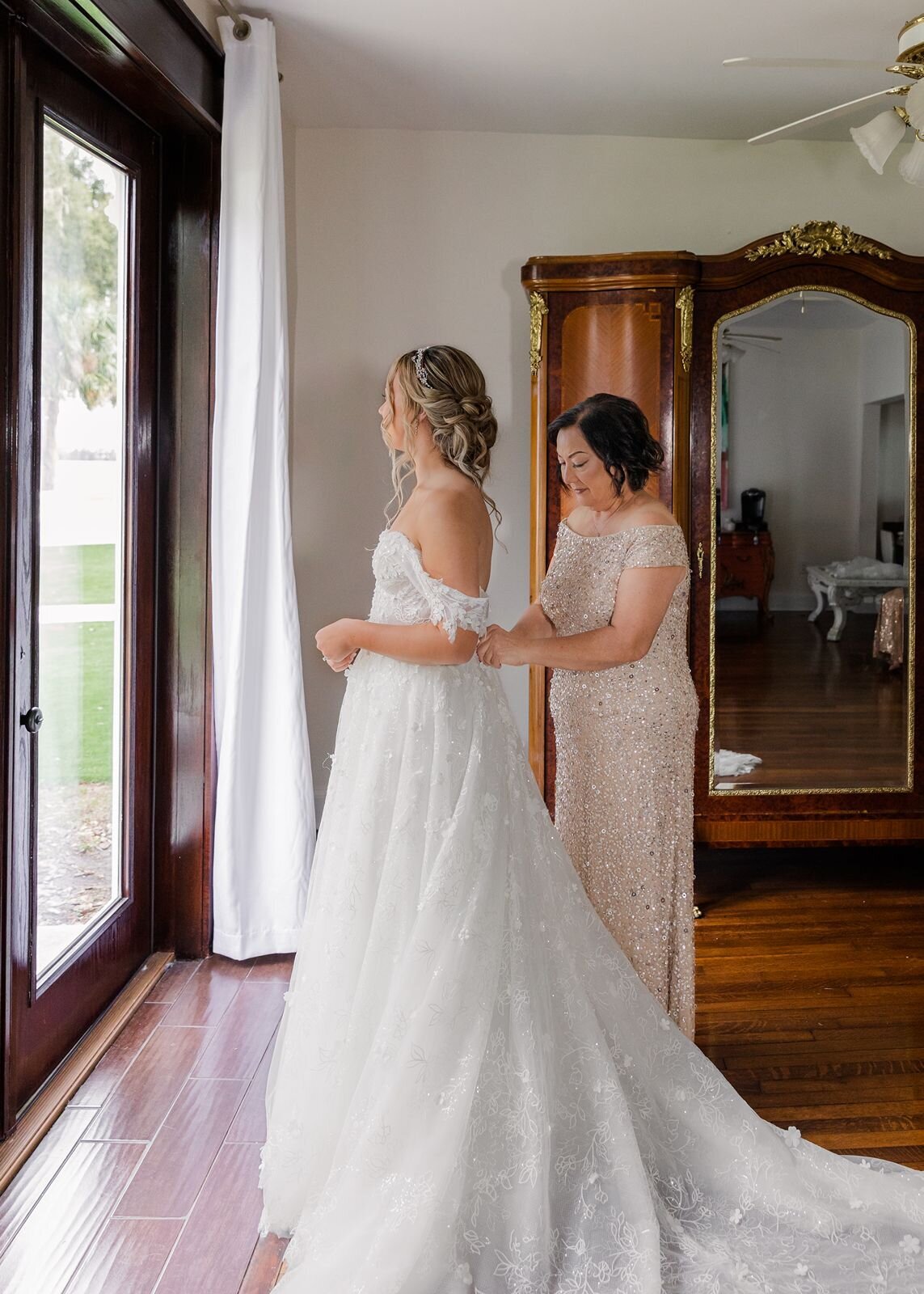 Mother buttoning brides dress at Bella Cosa, Lake Wales, Florida