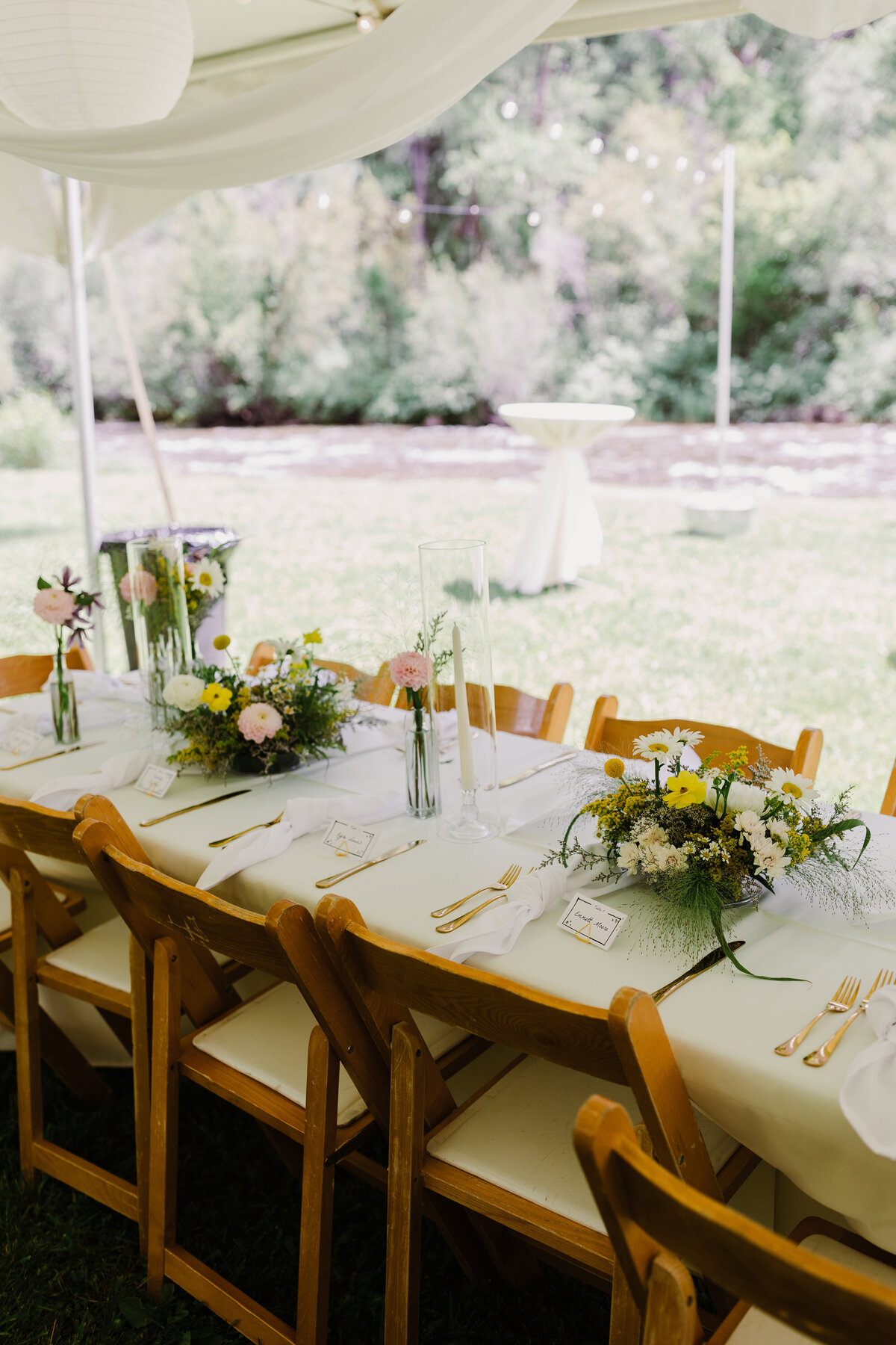 Outside wedding reception tables with wild flowers