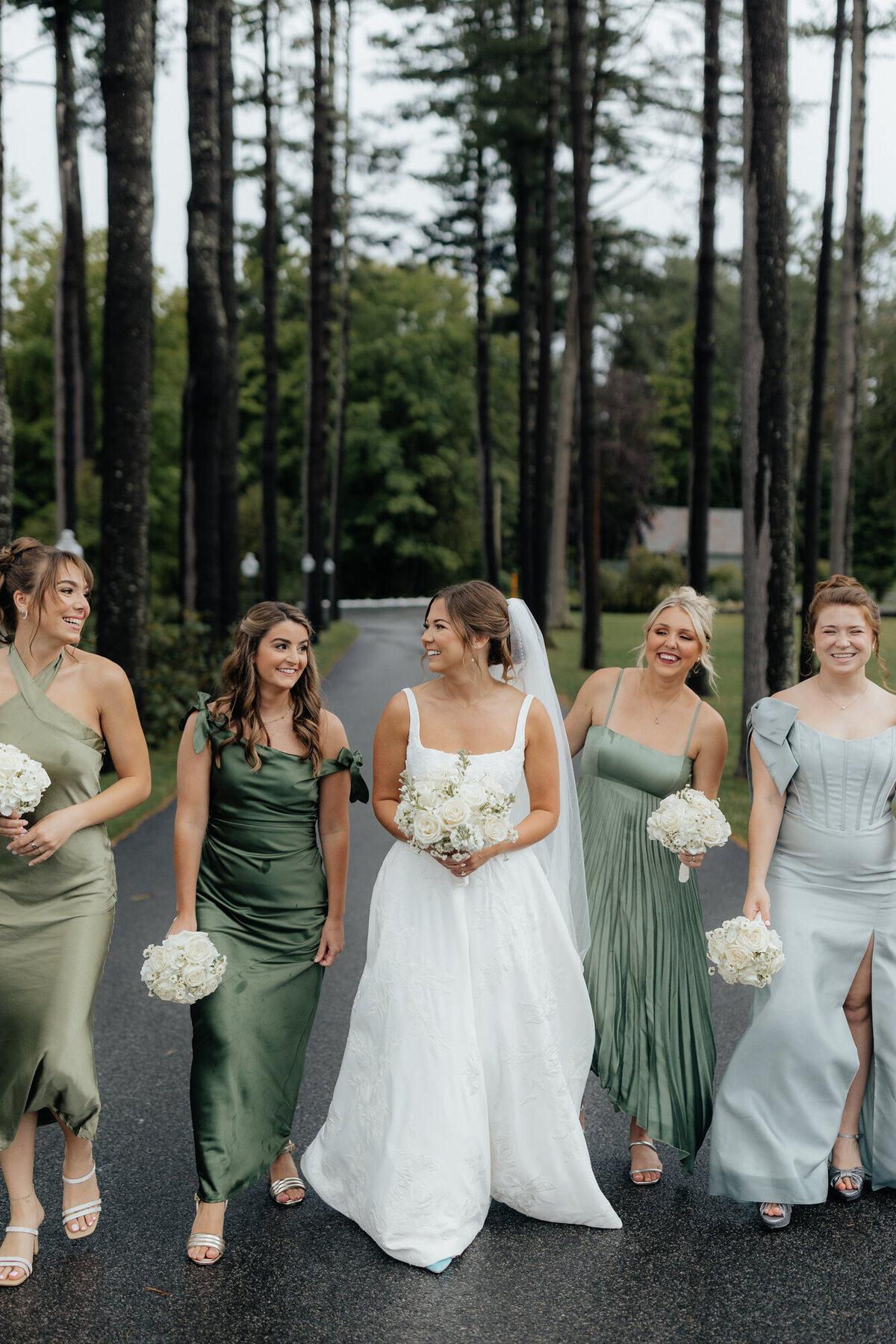 Bride with bridesmaids under umbrellas during light rain