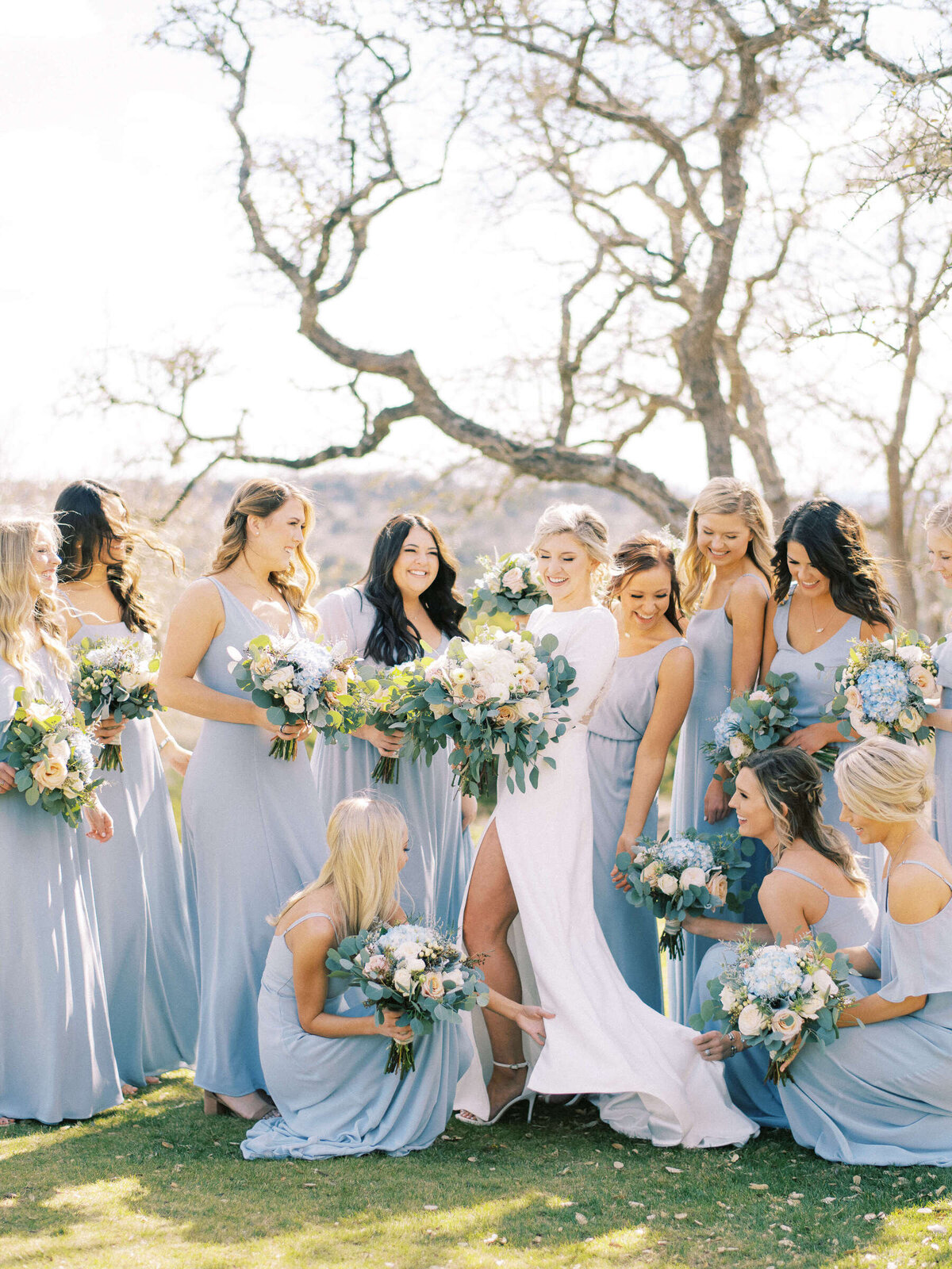 Bridesmaids help adjust young bride's dress for Texas wedding
