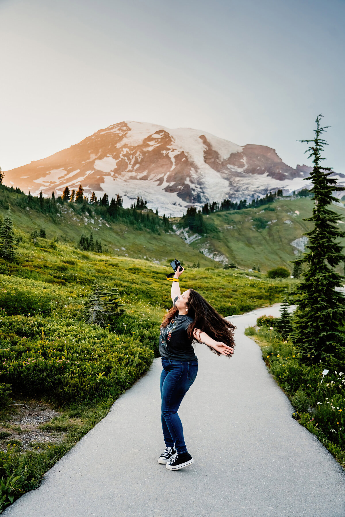 a photographer in front of mount rainier twirling