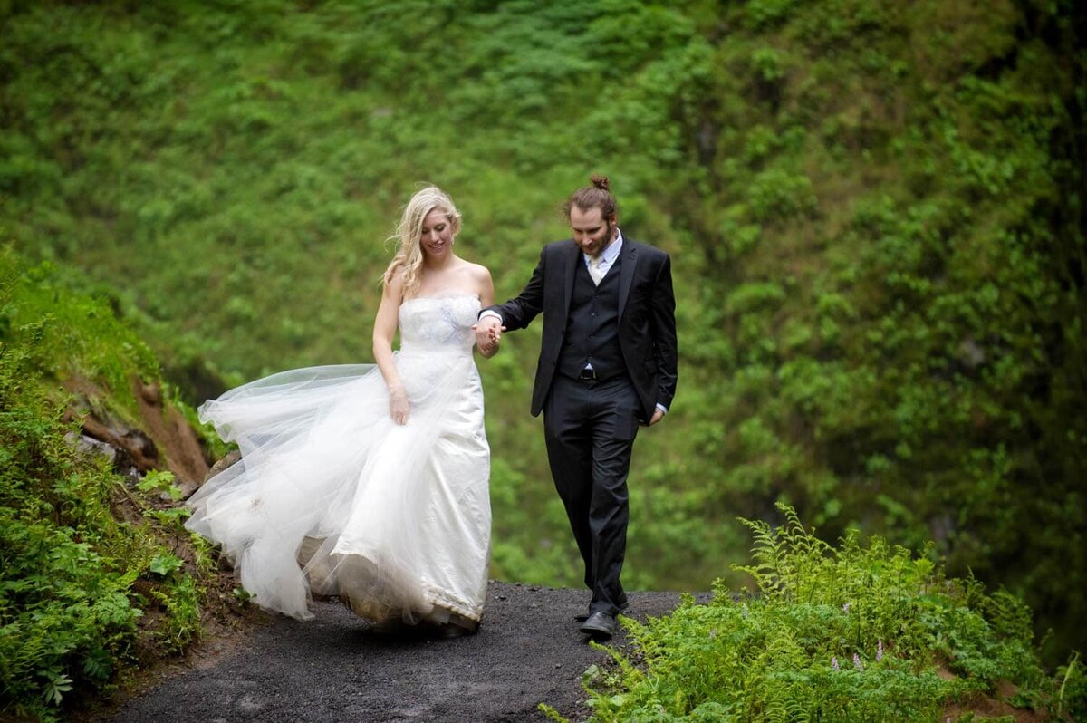 a couple walk surrounded by bright green moss covered walls