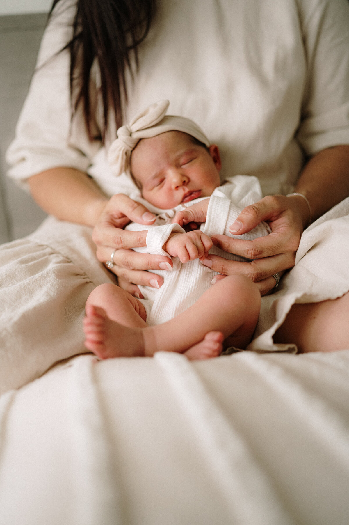 Sleepy newborn wrapped in a neutral blanket at home in Perth