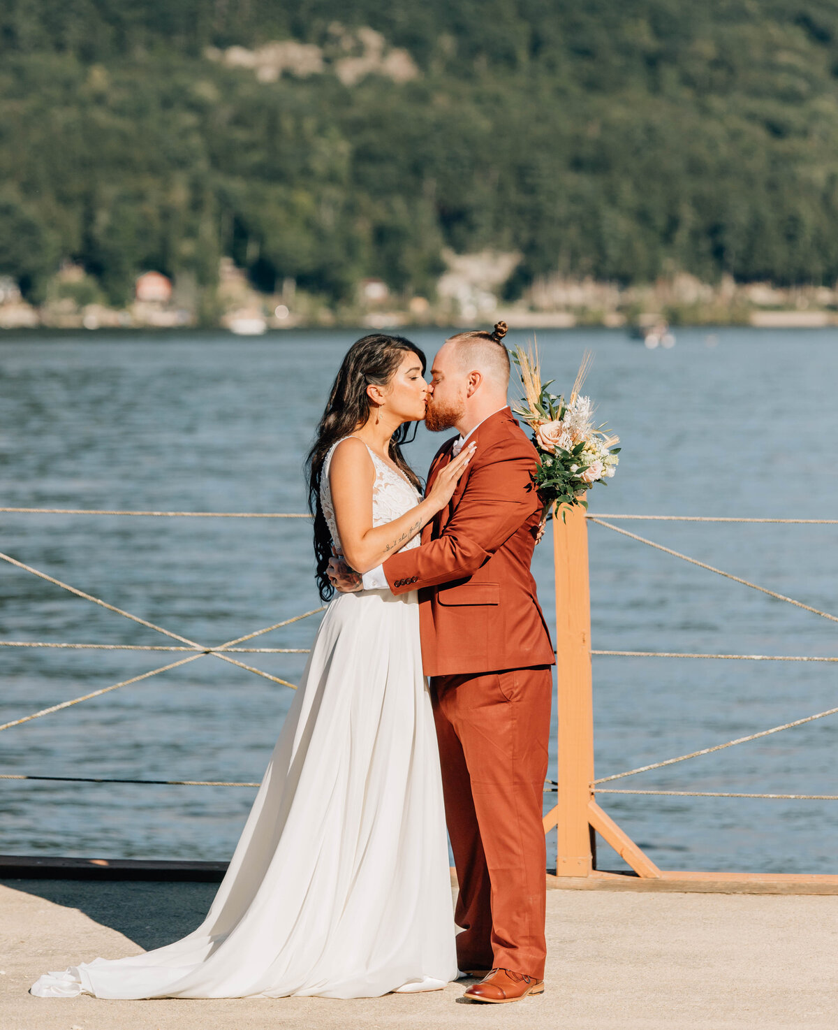 A couple shares a quiet, intimate kiss by the lake during their Vermont elopememt, captured with warmth and fine art detail