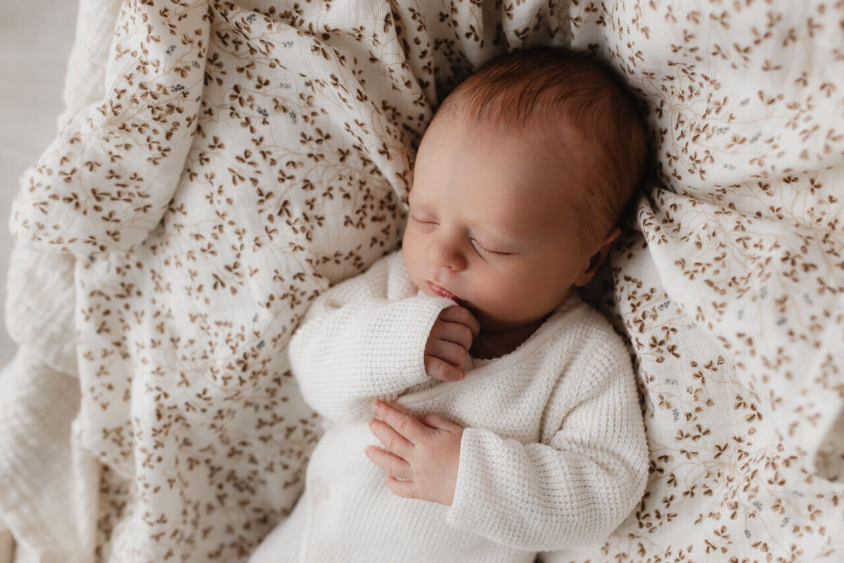 Newbornshoot van baby in bed